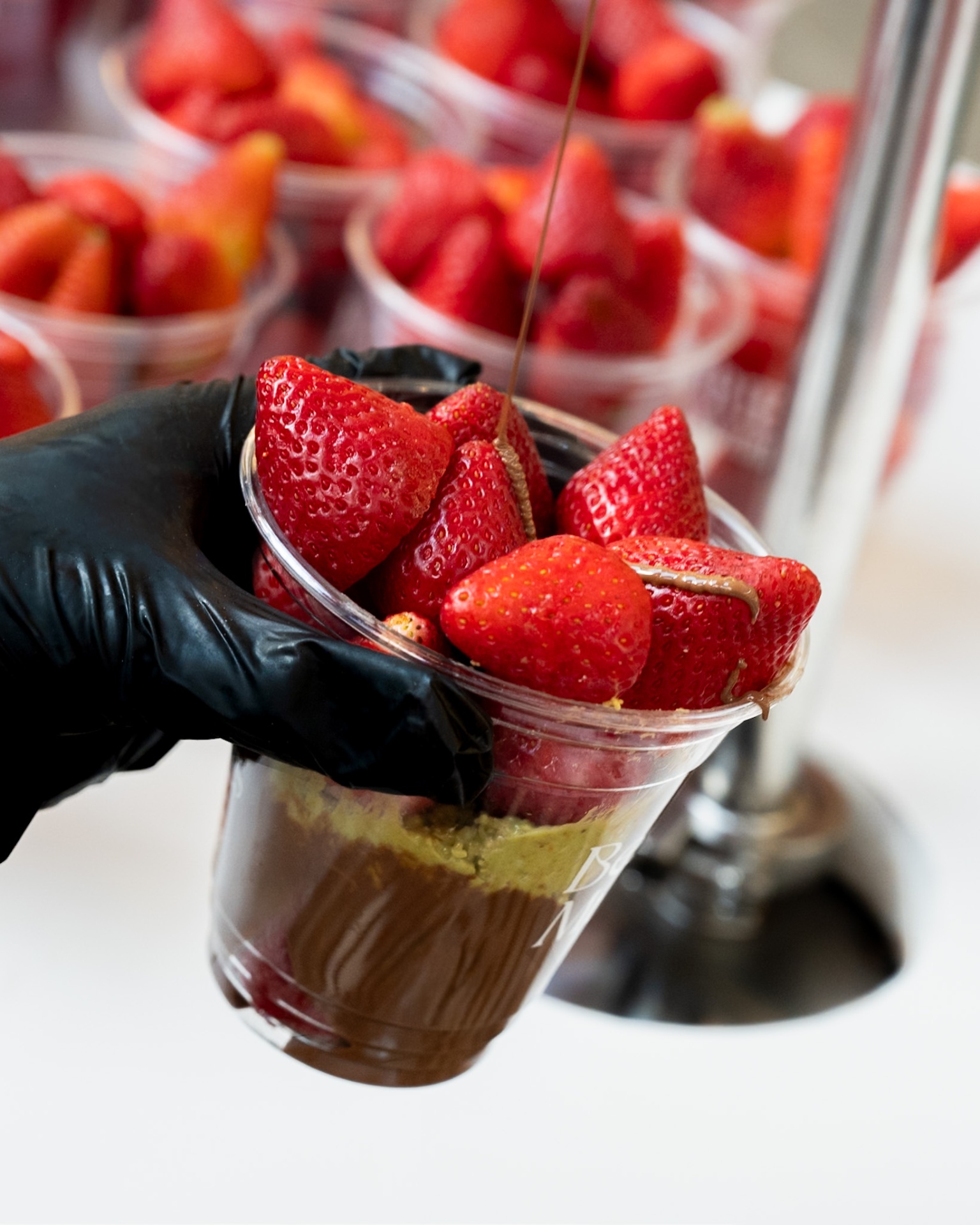Vaso de fresas con chocolate derretido cayendo — Berry Munch